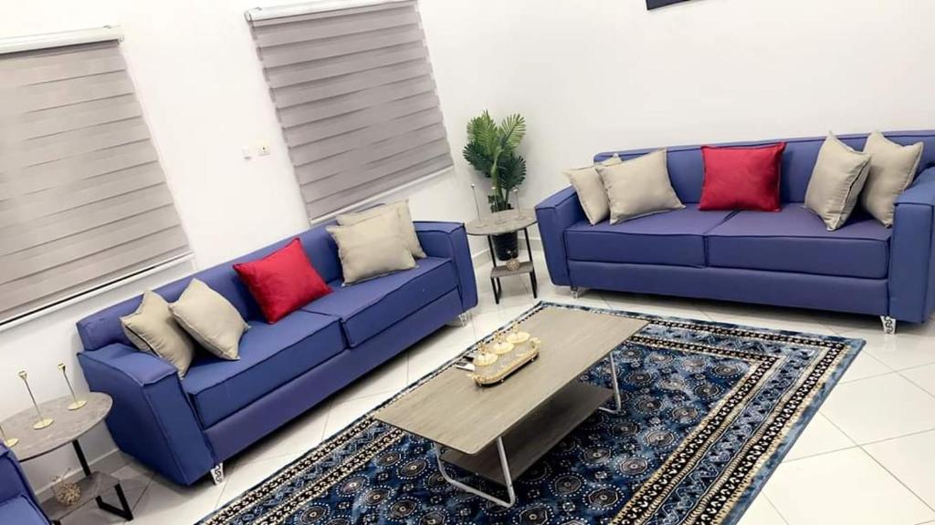 a living room with blue couches and a coffee table at Best Residence in Nouakchott