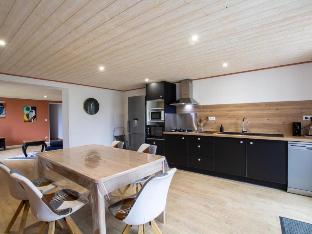 eine Küche und ein Esszimmer mit einem Holztisch und Stühlen in der Unterkunft Gîte Saint-Aulaye-Puymangou, 2 pièces, 2 personnes - FR-1-616-358 
