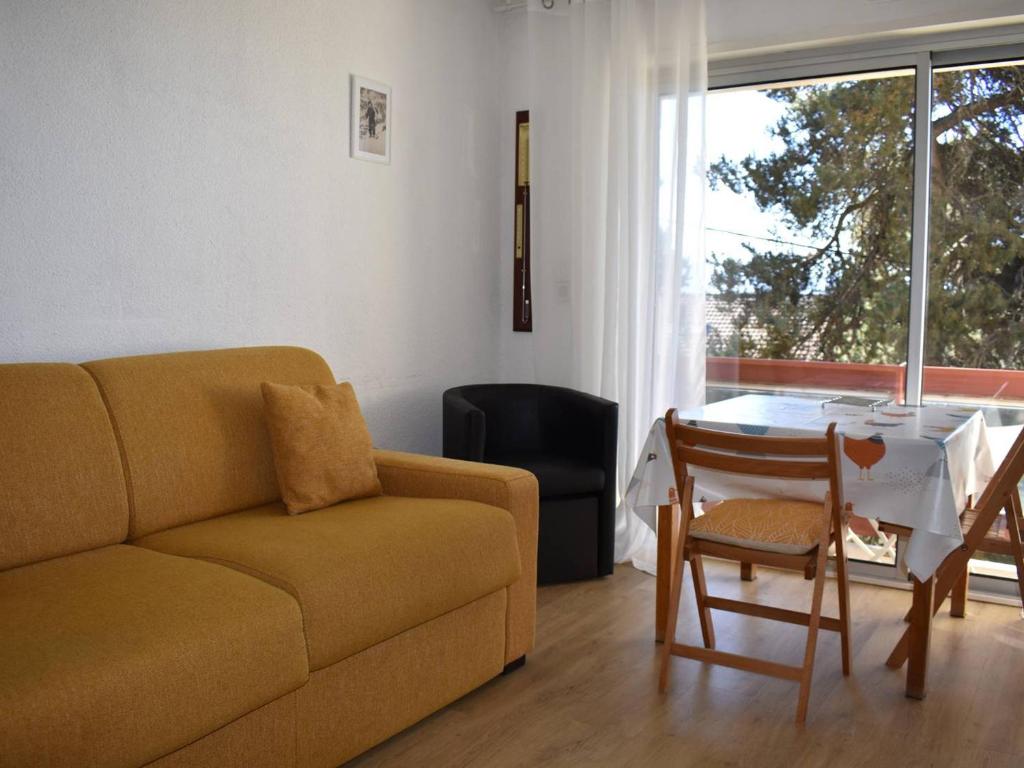 un salon avec un canapé et une table dans l'établissement Studio lumineux avec balcon, proche centre, garage et tout confort à Font-Romeu - FR-1-580-110, à Font-Romeu-Odeillo-Via