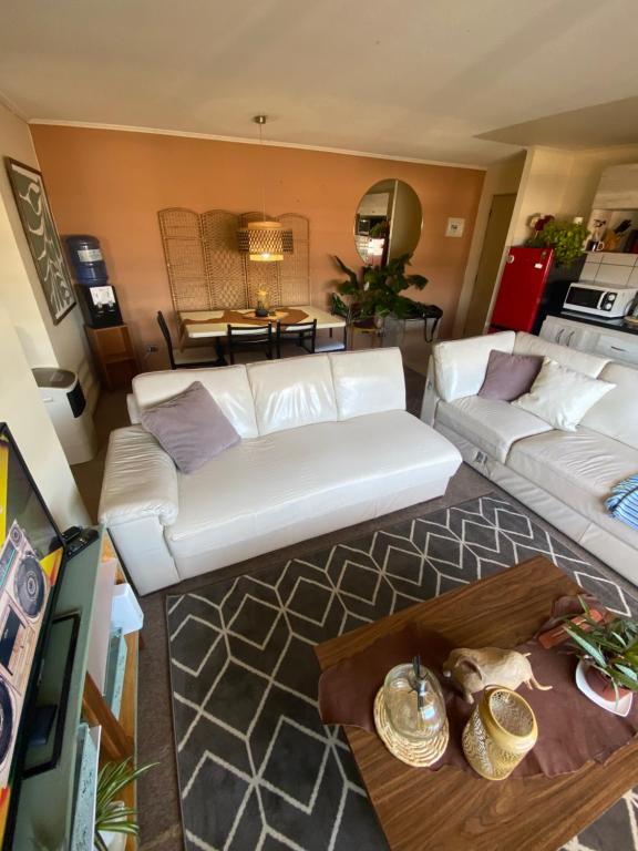 a living room with a white couch and a table at Departamento Centro Curicó in Curicó