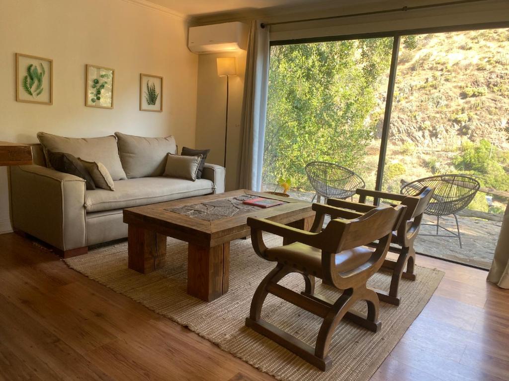 uma sala de estar com um sofá, uma mesa e cadeiras em Casa Camino Farellones em Santiago