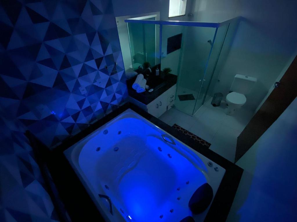 uma banheira azul na casa de banho com um chuveiro em Recanto Nova Canaã em Conceição de Jacuípe
