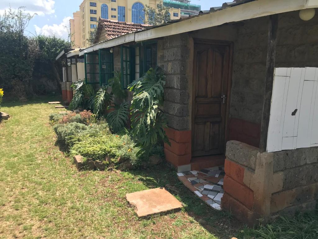 une maison en briques avec une porte et quelques plantes dans l'établissement Stone Cottages, Kilimani, à Nairobi