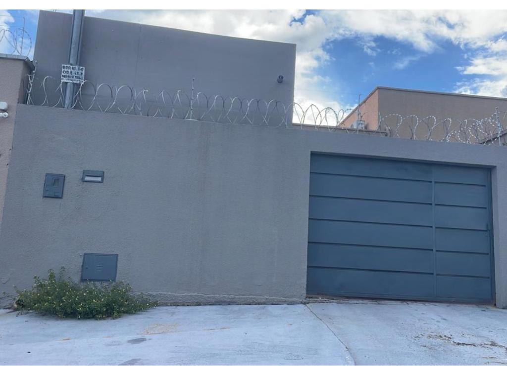 a building with a garage door on the side of it at Casa piscina 3 quartos in Goiânia