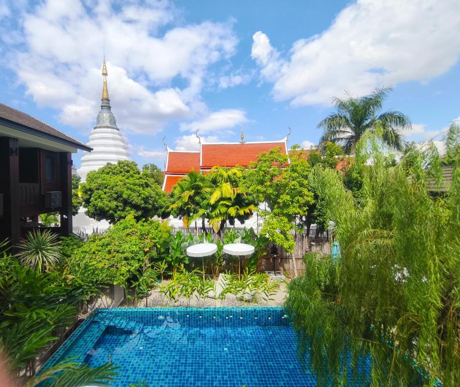 a resort with a swimming pool in front of a building at Arun Rawee อรุณ รวี in Chiang Mai