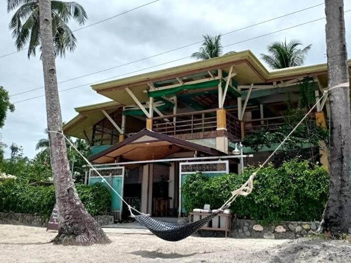 a resort with a hammock in front of a building at Greenviews Resort & Restaurant Port Barton in San Vicente