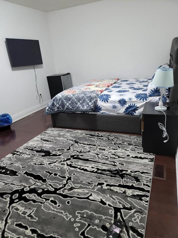 een slaapkamer met een bed en een tapijt bij Beautiful Langston Home in Brampton