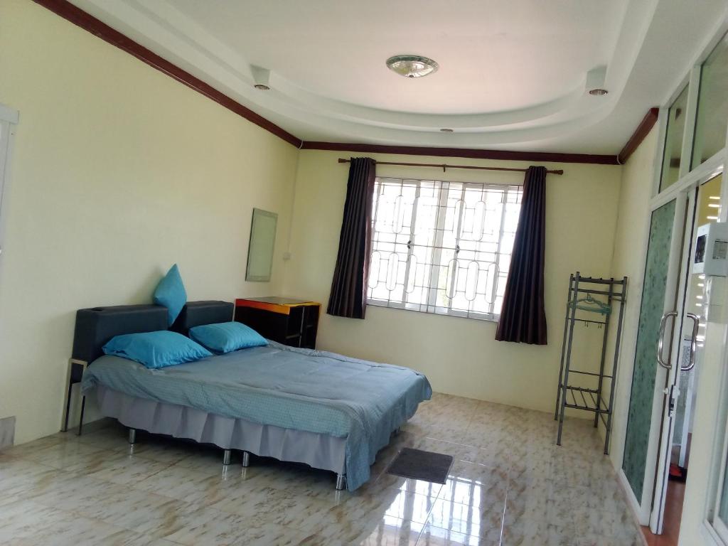 una camera da letto con letto e cuscini blu di กันตังใต้โฮมสเตย์Kangtangtai Homestay a Ban Laem Muang
