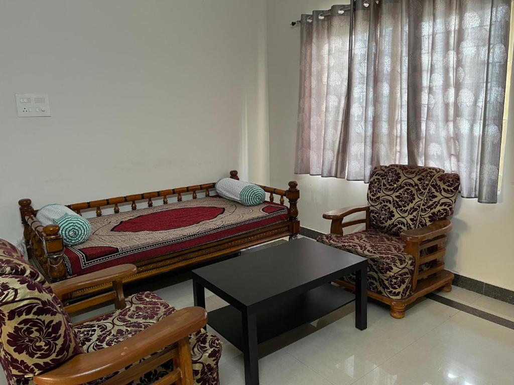 a bedroom with a bed and a chair and a table at 2 BHK Apartment at Gachibowli in Hyderabad