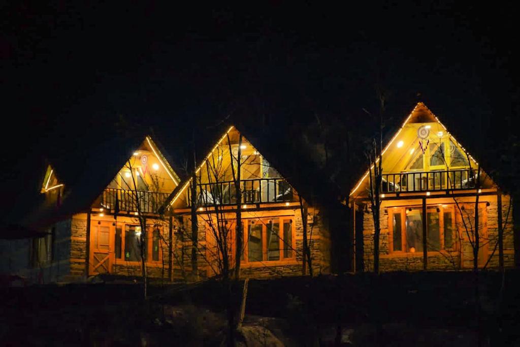 a house lit up at night with lights at Sainj Riverside Cottages in Sainj