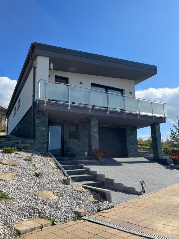 une maison avec un balcon sur le côté de celle-ci dans l'établissement Apartmánový dom Panoráma Park Vlková, 