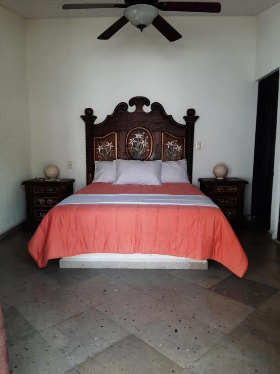 - une chambre avec un lit rouge et un ventilateur de plafond dans l'établissement Quinta Zana Hotel Boutique Sc, à Cuernavaca