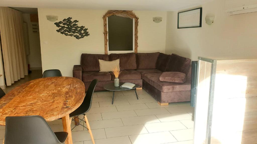 salon z kanapą i stołem w obiekcie Appartement le loft w Saintes-Maries-de-la-Mer