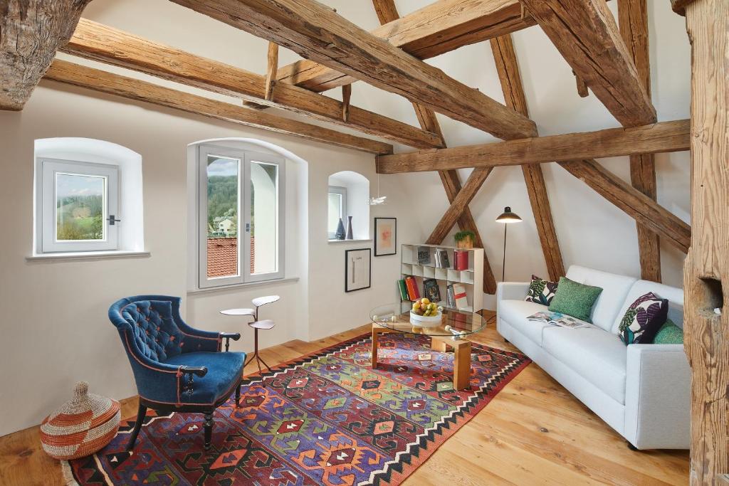 a living room with a white couch and a blue chair at Engelwirt Apartments in Berching