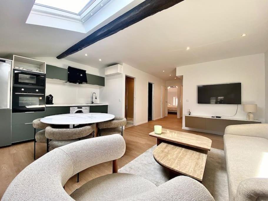 ein Wohnzimmer mit einem Tisch und Stühlen sowie eine Küche in der Unterkunft Cannes appartement 2 chambres - 19JDR in Cannes