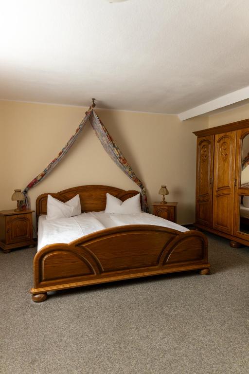 a bedroom with a large wooden bed with white pillows at Hotel Anker in Saalfeld