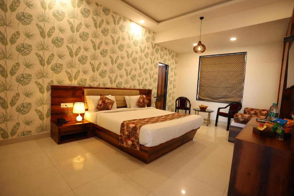 a bedroom with a bed and a living room at Hotel Bhairav Bagh with Swimming Pool in Udaipur