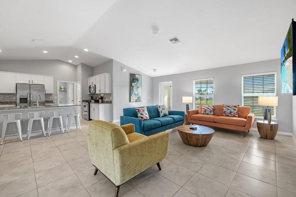 a living room with two couches and a kitchen at The Cape Escape Pet-Friendly Sleeps 7 in Cape Coral