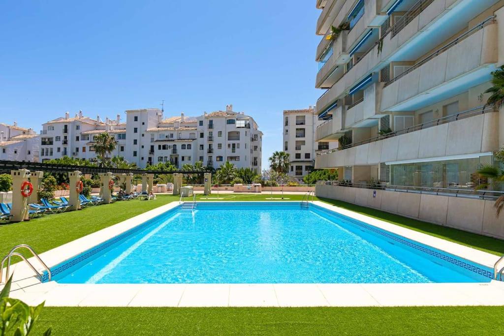 una piscina frente a un edificio en Luminous apartment in Puerto Banús, Marbella en Marbella