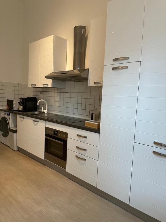 cocina con armarios blancos y fogones en Stilvolle Luxus City-Apartment en Viersen