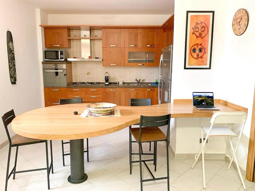 a kitchen with a wooden table and chairs at Appartamento al Lago in Castiglione del Lago