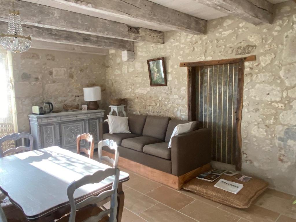 a living room with a couch and a table at Maison d hôtes Les Chantours dans réserve naturelle 15 hectares in Saint-Antoine-Cumond