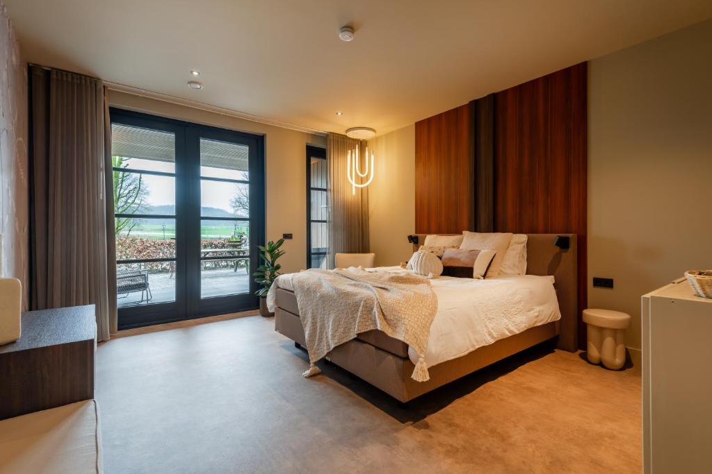 a bedroom with a bed and a large window at Tumuli Twente B&B Boutique Hotel in Nutter