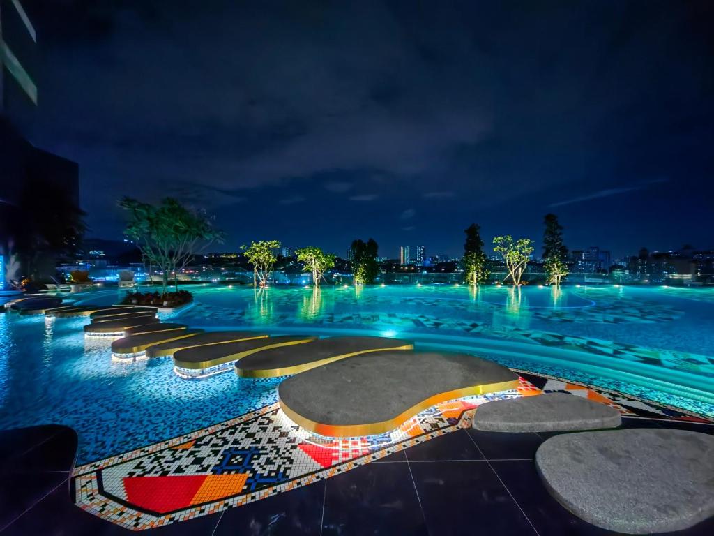 uma piscina à noite com árvores e luzes em Arte Cheras Duplex Suites em Kuala Lumpur