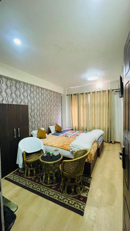 a bedroom with a large bed and a table and chairs at Hotel peace point dhulikhel in Dhulikhel