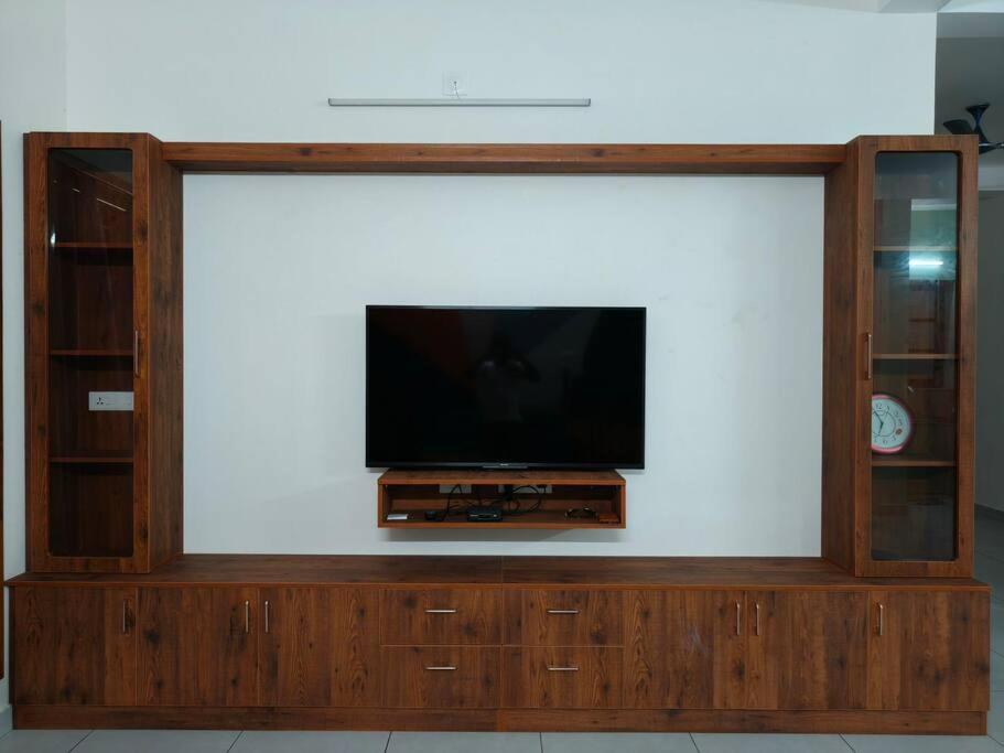 een flatscreen-tv in een houten entertainmentcentrum bij Happy HomeStay In Pondicherry in Pondicherry