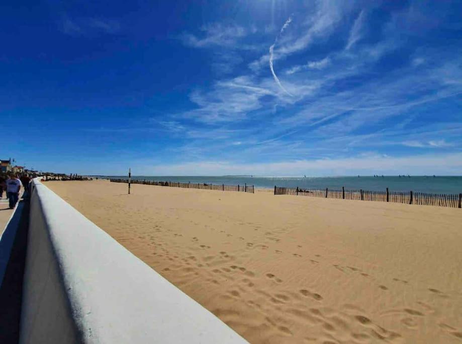 Blick auf einen Strand mit einer Person, die einen Drachen fliegt in der Unterkunft La Grande Croisée extérieur et plage in Châtelaillon-Plage