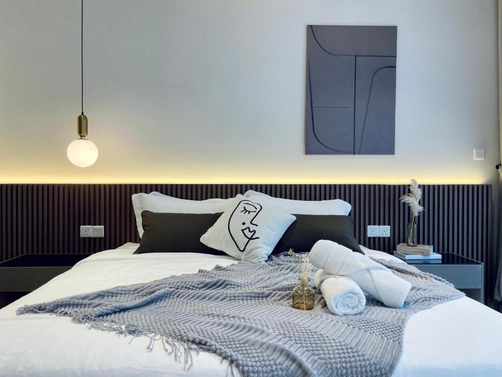 a bed with a blanket and pillows on it at QUILL RESIDENCE 1018 in Kuala Lumpur