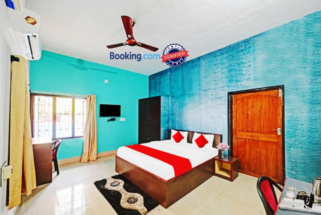 ein Schlafzimmer mit einem Bett und einer blauen Wand in der Unterkunft Hotel Madison Homes Bhubaneswar Near Lingaraj Temple and Ram Mandir in Bhubaneshwar