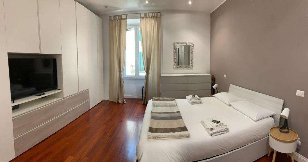 a white room with a bed and a television at A casa di Cesare in Rome