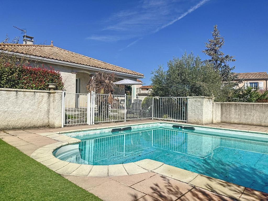 ein Schwimmbad in einem Garten neben einem Zaun in der Unterkunft Villa de charme avec piscine in Aguessac