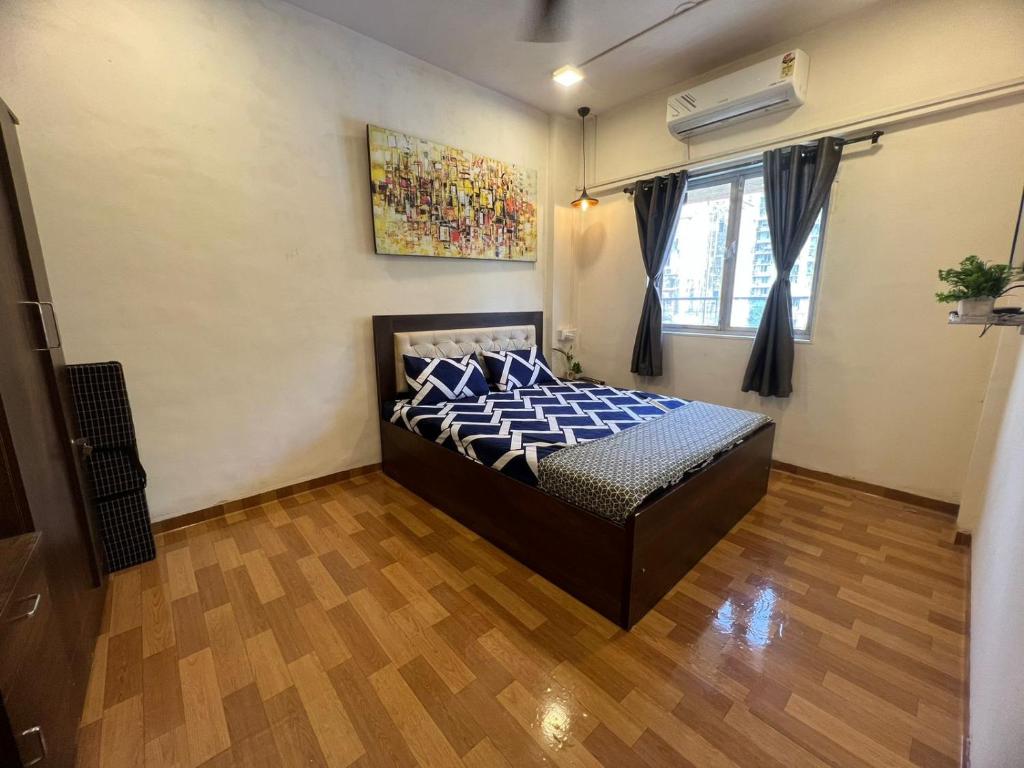 een slaapkamer met een bed met blauwe kussens erop bij Sixth Sense Lokhandwala in Mumbai