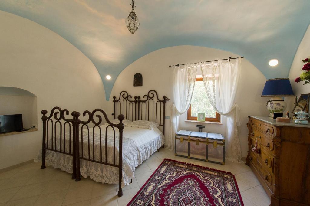 een slaapkamer met een bed, een dressoir en een raam bij Agriturismo Masseria Pozzo in Sperlonga