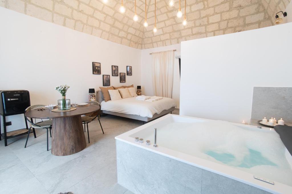a large bath tub in a living room with a table at Vicoloterzo Suite in Bari