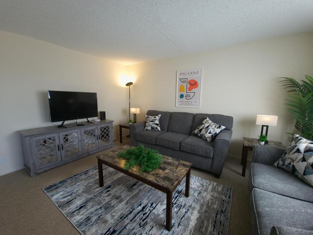a living room with a couch and a tv at Castro Place in Downtown San Leandro in San Leandro