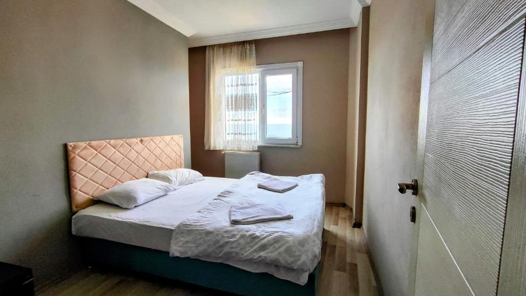 a small bedroom with a bed with a window at elva suites ardeşen in Ardeşen