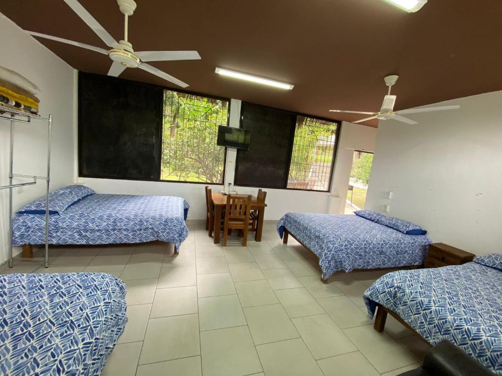 een kamer met 2 bedden en een tafel en stoelen bij Cabañas El Sabinito in El Naranjo