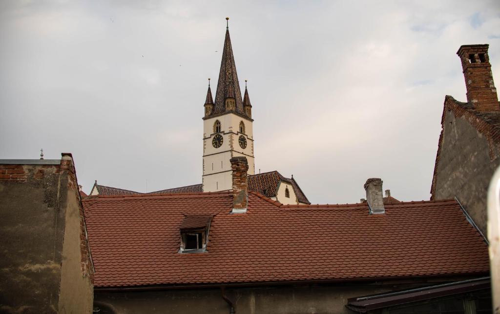 a clock tower on top of a building with a roof at Studio Sonia - Tordosan Central - #5 in Sibiu