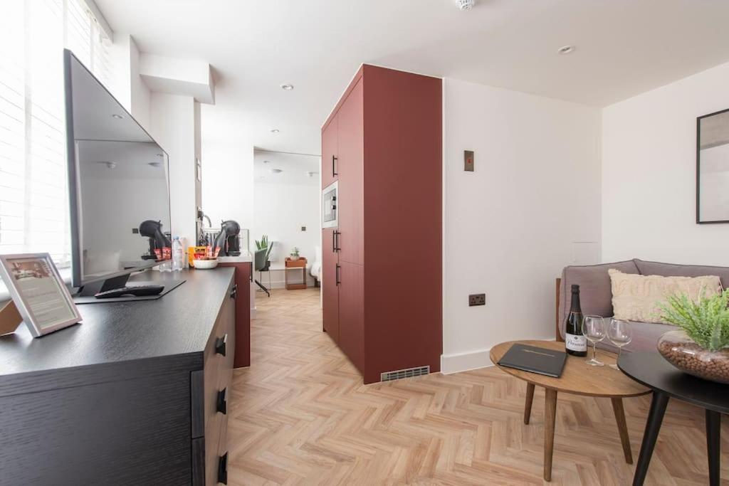 uma cozinha e sala de estar com um balcão e um sofá em Cityscape Charm Studio - Central London em Londres