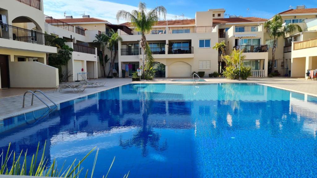 a large blue swimming pool in front of a building at The Olive Grove Escape, Eleonas Apts in Sotira
