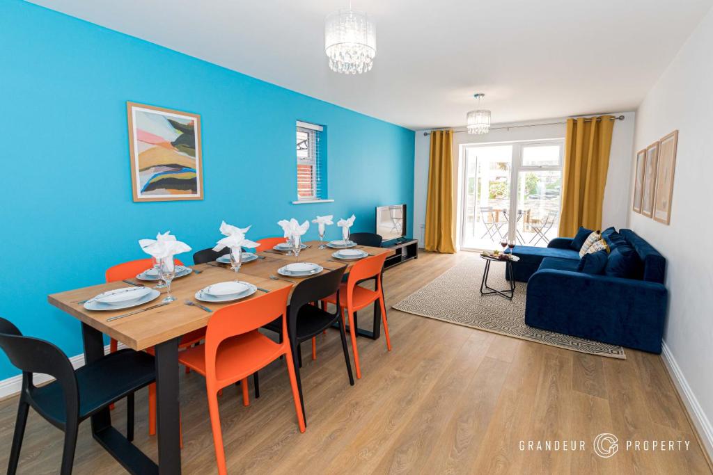 a dining room with a table and a blue wall at Spacious & modern 3 bed, 10 min to beach, parking - Lyell House in Poole