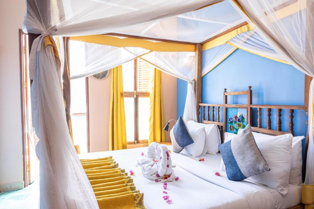 a bedroom with a white bed with a canopy at Shaba Boutique Hotel in Zanzibar City