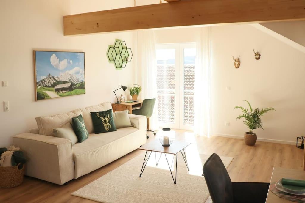 ein Wohnzimmer mit einem Sofa und einem Tisch in der Unterkunft WIESENglück in Altusried