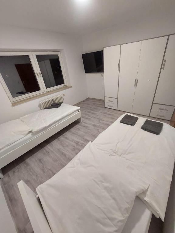 a white room with two beds and a window at Lübeck Zentral nähe Autobahn in Lübeck