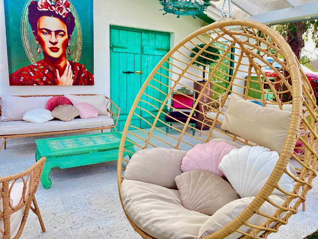 una habitación con dos sillas colgantes y una pintura de una mujer en Bohemian weekendhouse at lake Balaton, en Diskahegy