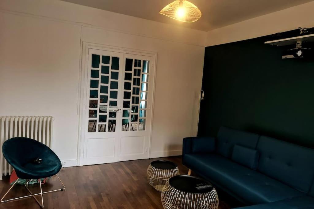 a living room with a blue couch and a window at L'Art Déco - Maison + Parking (Portes de Chartres) in Jouy